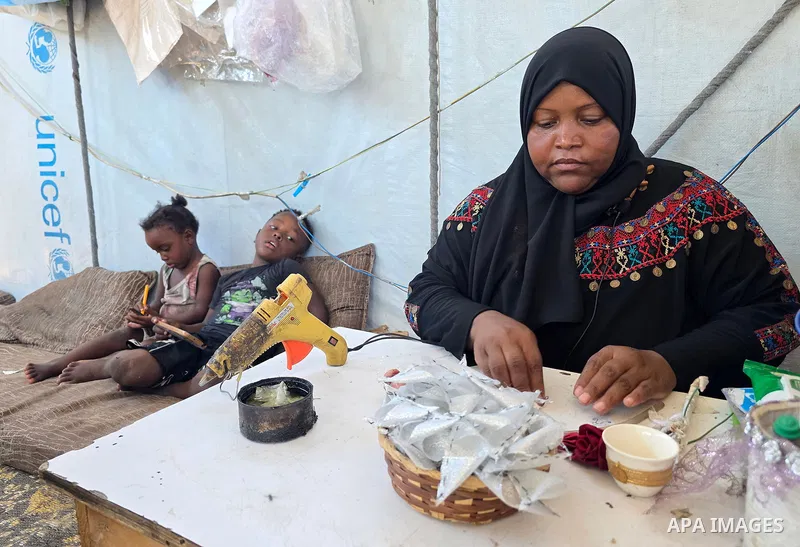 Displaced Palestinian Shireen Nassar prepares wedding supplies inside her tent in the al-Mawasi area, west of Khan Younis, southern Gaza Strip, on July 22, 2026. Nassar has transformed the tent into both a workspace and...