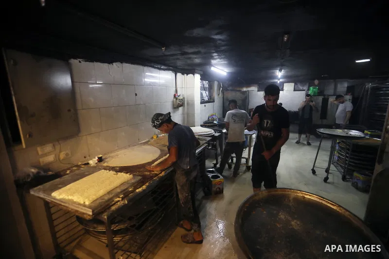 Workers prepare assorted sweets at a confectionery shop in Gaza City on July 23, 2026, a day before the announcement of the Palestinian General Secondary Education Examination (Tawjihi) results, as families prepare to ce...