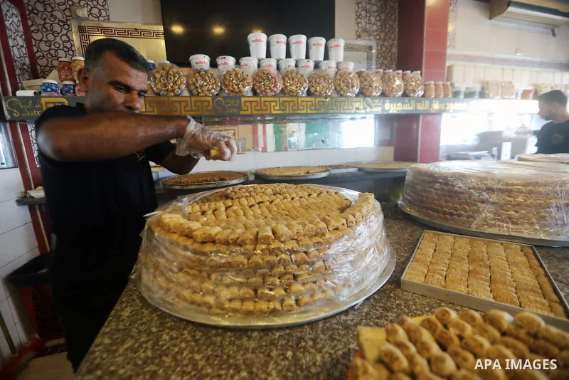 Workers prepare assorted sweets at a confectionery shop in Gaza City on July 23, 2026, a day before the announcement of the Palestinian General Secondary Education Examination (Tawjihi) results, as families prepare to ce...