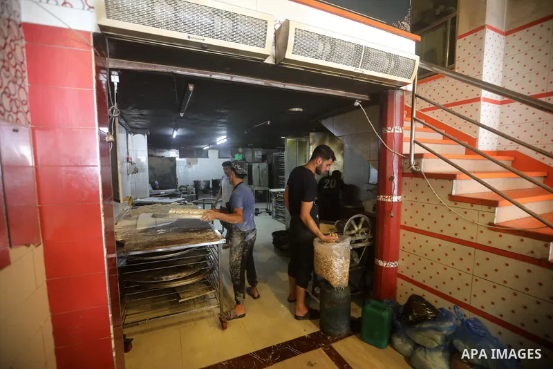 Workers prepare assorted sweets at a confectionery shop in Gaza City on July 23, 2026, a day before the announcement of the Palestinian General Secondary Education Examination (Tawjihi) results, as families prepare to ce...