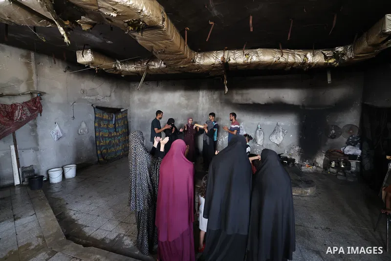 Palestinian student Raghad Hajjaj celebrates with her family after achieving a score of 96 percent in the scientific stream of the Tawjihi (high school) examinations inside the damaged Islamic University in Gaza City, Ga...