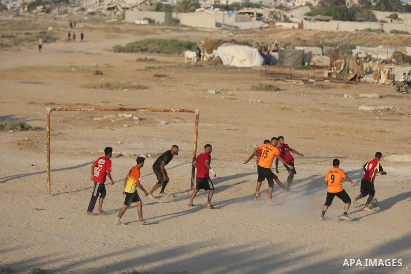 Palestinians take part in the final match of a football tournament organized by young people living in temporary tents sheltering displaced families in Nuseirat refugee camp, central Gaza Strip, on August 1, 2026. Held i...