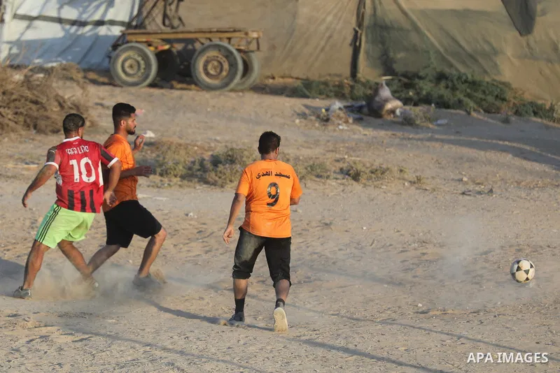 Palestinians take part in the final match of a football tournament organized by young people living in temporary tents sheltering displaced families in Nuseirat refugee camp, central Gaza Strip, on August 1, 2026. Held i...