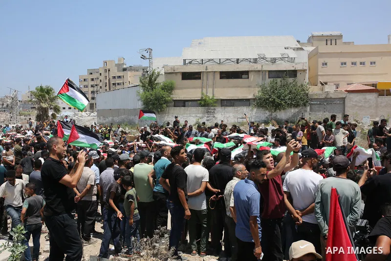 Palestinians attend the funeral of 112 members of the Hassayna and Abu Sharia clans, who were killed in an Israeli strike in 2023 and whose remains were recovered from beneath the rubble, according to Gaza's Civil Defens...