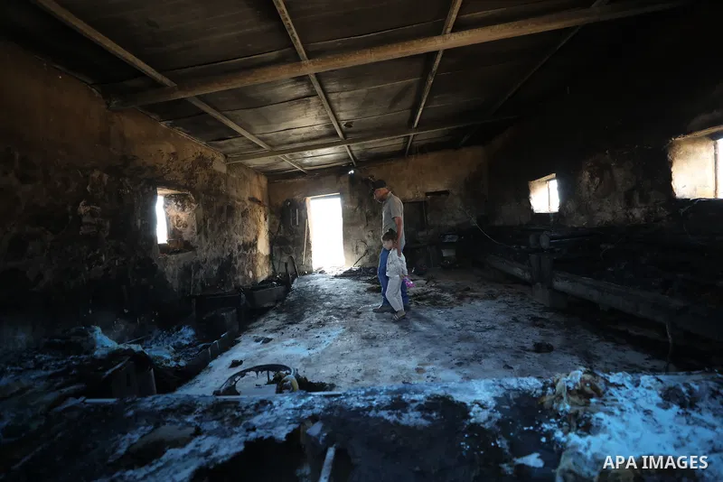 Palestinians inspect damage in Khirbet al-Tuba, in the Masafer Yatta area south of Hebron in the occupied West Bank, on August 6, 2026, after residents said Israeli settlers attacked the community, damaging several homes...