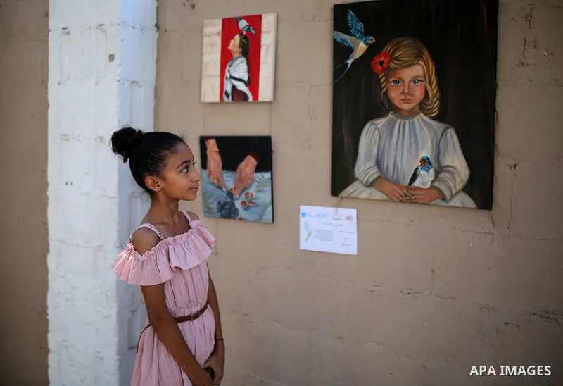 Palestinians attend the “Brush of Peace” exhibition featuring artworks and drawings by young women from Gaza City on August 30, 2026. The exhibition highlights artistic expression amid wartime conditions and presents the...