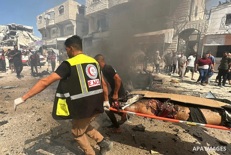 Palestinians gather at the site of an Israeli strike that targeted a civilian vehicle in the Tal al-Hawa neighborhood of Gaza City on August 31, 2026, as firefighters try to extinguish a fire at the scene. Medics recover...