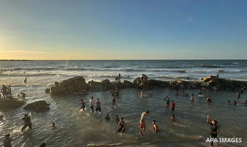 Displaced Palestinians spend time on the beach in Gaza City, in the Gaza Strip, on September 25, 2026, seeking relief from high temperatures and difficult living conditions inside displacement and shelter tents. Many dis...