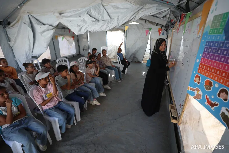 Palestinian students attend a lesson inside a tent in al-Bureij camp in the central Gaza Strip on September 26, 2026, as the new academic year resumes. Classes are being held amid widespread damage to schools and shortag...