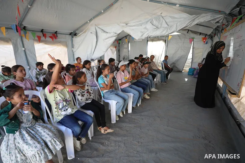 Palestinian students attend a lesson inside a tent in al-Bureij camp in the central Gaza Strip on September 26, 2026, as the new academic year resumes. Classes are being held amid widespread damage to schools and shortag...