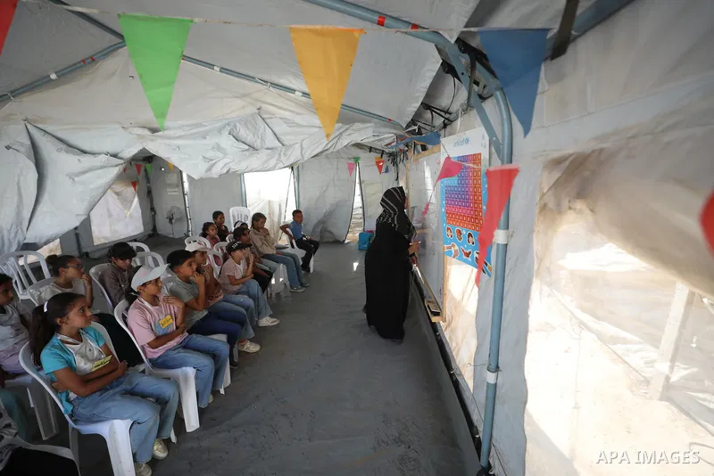 Palestinian students attend a lesson inside a tent in al-Bureij camp in the central Gaza Strip on September 26, 2026, as the new academic year resumes. Classes are being held amid widespread damage to schools and shortag...