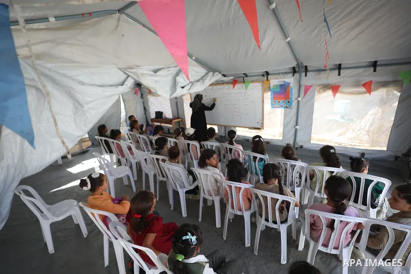 Palestinian students attend a lesson inside a tent in al-Bureij camp in the central Gaza Strip on September 26, 2026, as the new academic year resumes. Classes are being held amid widespread damage to schools and shortag...