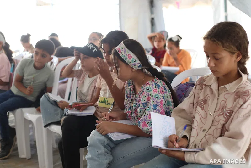 Palestinian students attend a lesson inside a tent in al-Bureij camp in the central Gaza Strip on September 26, 2026, as the new academic year resumes. Classes are being held amid widespread damage to schools and shortag...