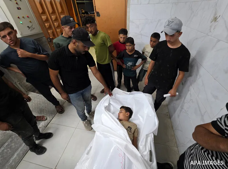 Medics carry the body of eight-year-old Mohammed Seif al-Din al-Shukhriti to Nasser Medical Complex in Khan Younis, southern Gaza Strip, on September 26, 2026, after he was killed by Israeli gunfire while playing outside...