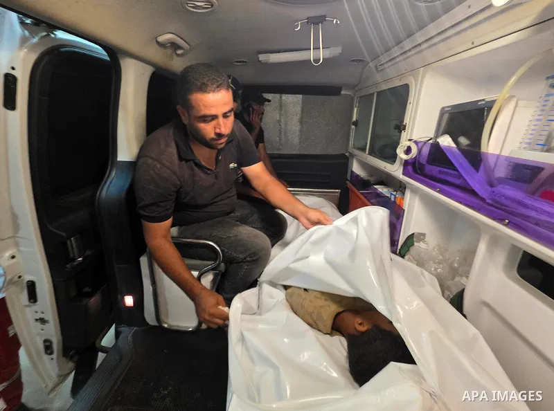 Medics carry the body of eight-year-old Mohammed Seif al-Din al-Shukhriti to Nasser Medical Complex in Khan Younis, southern Gaza Strip, on September 26, 2026, after he was killed by Israeli gunfire while playing outside...