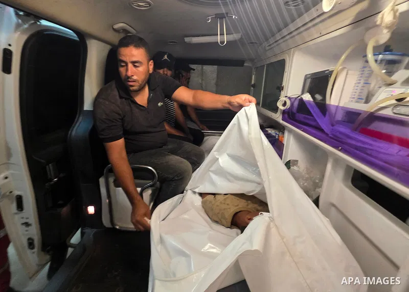 Medics carry the body of eight-year-old Mohammed Seif al-Din al-Shukhriti to Nasser Medical Complex in Khan Younis, southern Gaza Strip, on September 26, 2026, after he was killed by Israeli gunfire while playing outside...