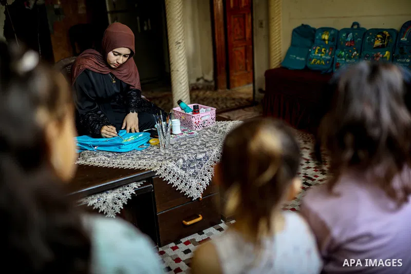 Palestinian visual artist Hala Abu Hamda, 18, paints and colors children’s bags inside her home in the al-Nasr neighborhood of Gaza City on September 27, 2026, as the new academic year begins. Students in the Gaza Strip...