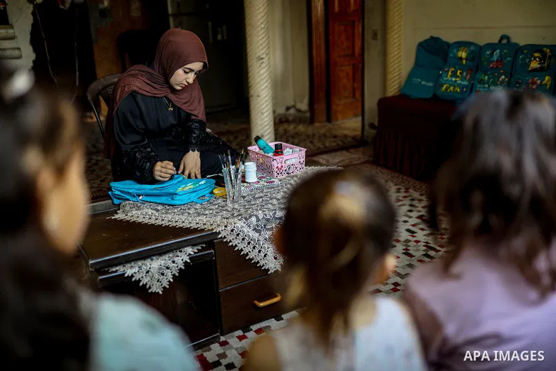 Palestinian visual artist Hala Abu Hamda, 18, paints and colors children’s bags inside her home in the al-Nasr neighborhood of Gaza City on September 27, 2026, as the new academic year begins. Students in the Gaza Strip...
