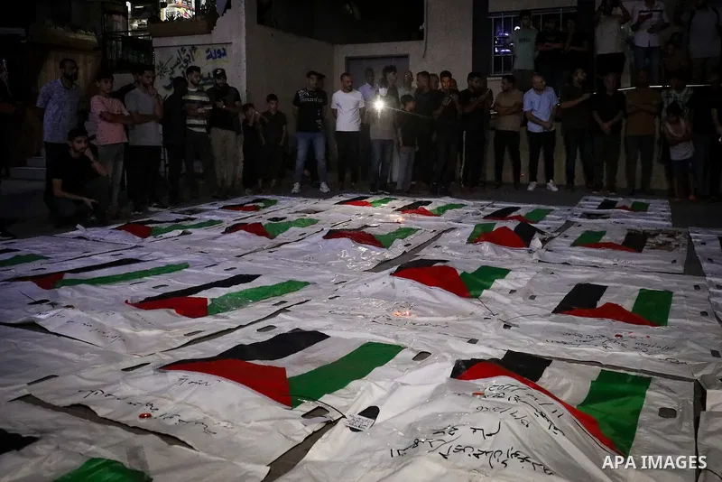 Palestinians light candles and mourn beside the bodies of loved ones recovered from beneath the rubble of destroyed homes outside Al-Awda Hospital in the Nuseirat refugee camp, central Gaza Strip, on September 28, 2026....