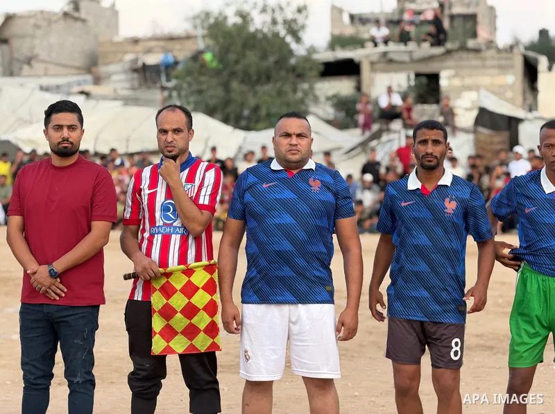 Former Palestinian national team players and local footballers take part in a friendly match amid displacement camps in Khan Younis, southern Gaza Strip, on October 2, 2026. The match was organized as an initiative to ea...