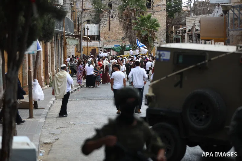 Israeli soldiers restrict the movement of Palestinians and take security measures during a tour by Israeli settlers in the Old City of Hebron, in the West Bank, on October 3, 2026, during the Jewish holiday of Sukkot. Ph...