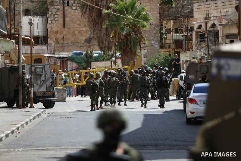 Israeli soldiers restrict the movement of Palestinians and take security measures during a tour by Israeli settlers in the Old City of Hebron, in the West Bank, on October 3, 2026, during the Jewish holiday of Sukkot. Ph...