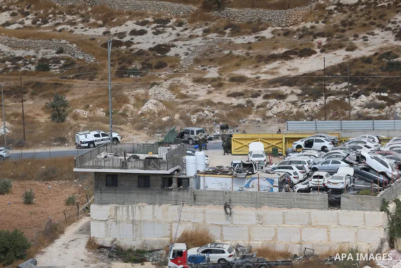 Israeli soldiers stand around a vehicle near the entrance to Bani Naim, southeast of Hebron, in the West Bank, on October 5, 2026, after it was fired upon, according to local sources and the Palestinian News and Informat...