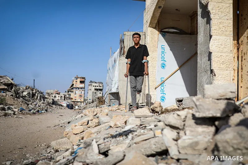 Palestinian boy Muath Ashraf al-Deini struggles to continue his life with one leg, using crutches amid the rubble in the Abu Iskandar area of the northern Gaza Strip, on October 8, 2026. More than two years after he was...