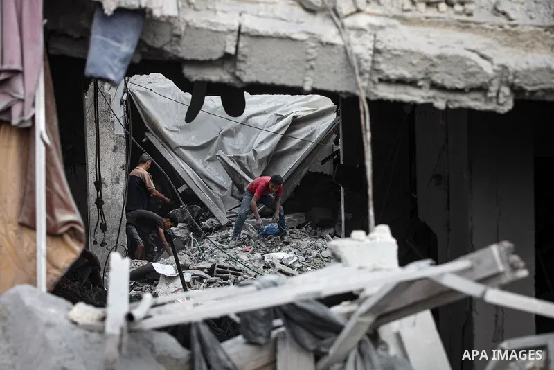 Palestinians inspect their belongings amid the rubble of damaged residential buildings after an Israeli airstrike targeted a residential block in Al-Zawayda, in the central Gaza Strip, on October 11, 2026. Photo by Moiz...