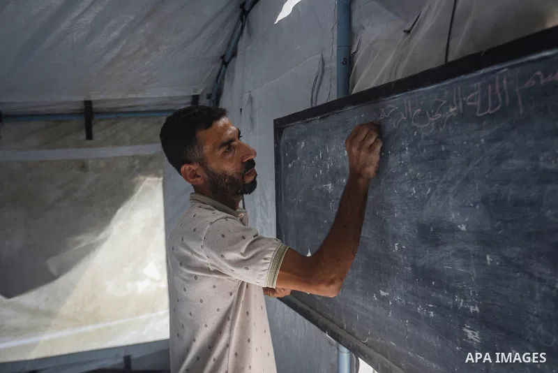 Palestinian students attend classes inside tents at the Saraya education point in the Gaza Strip on October 11, 2026, as education continues under difficult conditions and with shortages of school equipment. Students sit...