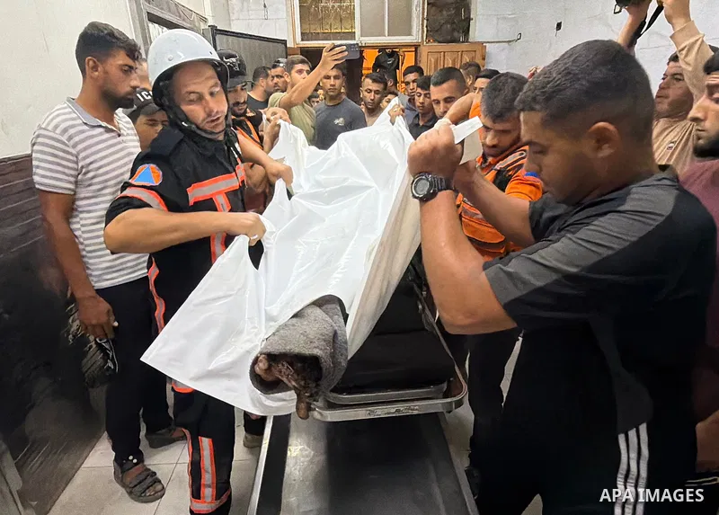Palestinians transport the bodies of three people killed and several others wounded to Nasser Medical Complex following a strike on a tent in al-Buraq camp, west of Khan Younis in the southern Gaza Strip, on October 11,...