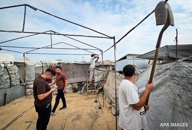 Palestinian workers erect tents using metal rods salvaged from the rubble of destroyed homes in the Al-Mawasi area of Khan Younis, in the southern Gaza Strip, on October 12, 2026, in preparation for winter amid deteriora...