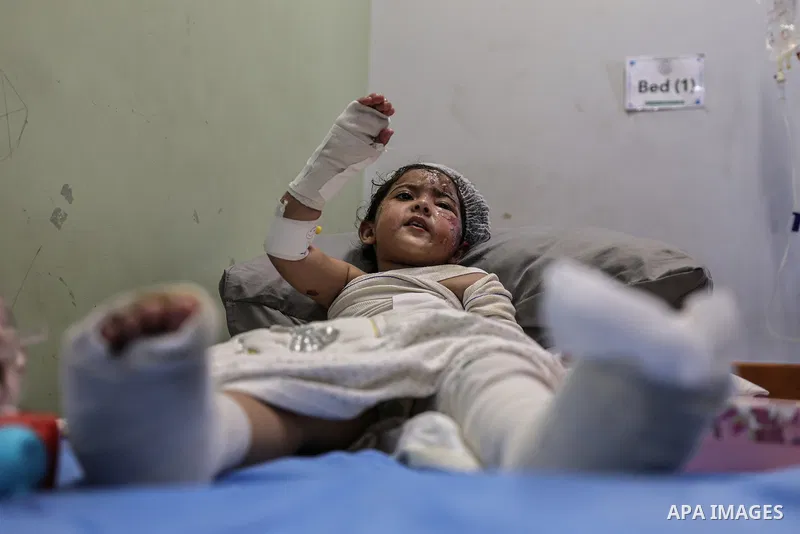 Palestinian child Maryam Ganem, two and a half years old, receives medical treatment for burns at al-Shifa Hospital in Gaza City, on October 15, 2026, as relatives stay by her side. Ganem was orphaned after her family wa...