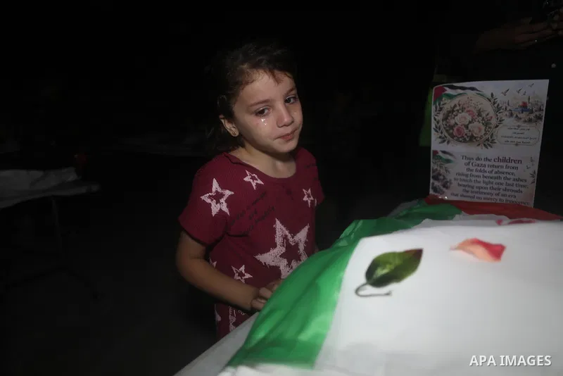 Mourners attend the funeral of 75 Palestinians whose bodies were recovered by Civil Defense teams in the al-Daraj area, northeast of Gaza City, on October 17, 2026. Relatives gather to bid farewell to their loved ones du...
