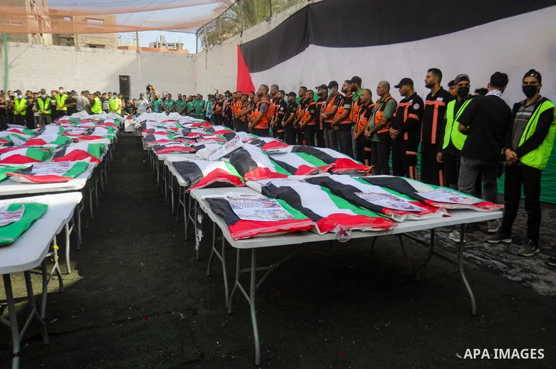 Mourners attend the funeral of 75 Palestinians whose remains were recovered by Civil Defense teams from beneath the rubble of buildings destroyed in Israeli airstrikes during the war in the al-Daraj neighborhood, northea...