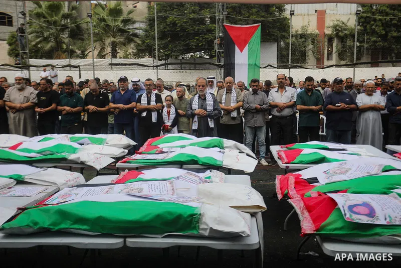Mourners attend the funeral of 75 Palestinians whose remains were recovered by Civil Defense teams from beneath the rubble of buildings destroyed in Israeli airstrikes during the war in the al-Daraj neighborhood, northea...