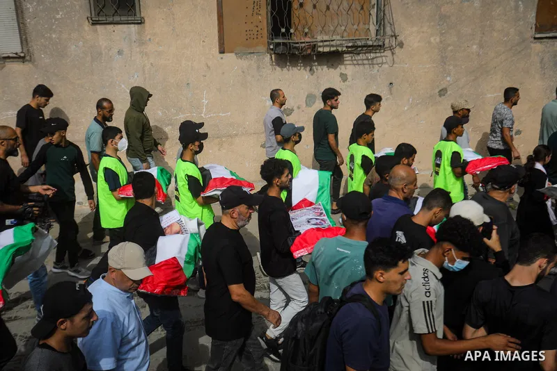 Mourners attend the funeral of 75 Palestinians whose remains were recovered by Civil Defense teams from beneath the rubble of buildings destroyed in Israeli airstrikes during the war in the al-Daraj neighborhood, northea...