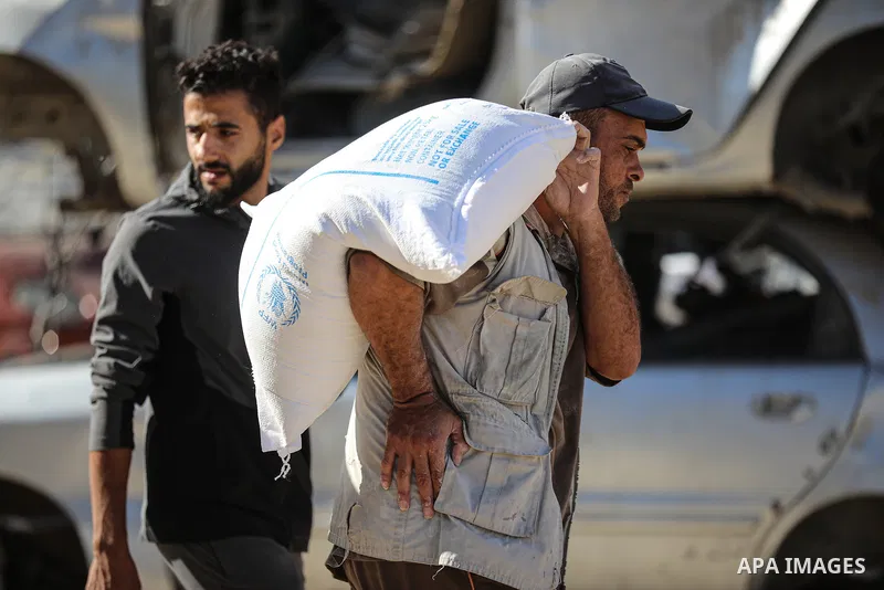 Palestinians receive food parcels distributed by the World Food Programme (WFP) at the Nuseirat refugee camp in the central Gaza Strip, on October 20, 2026. Many families continue to rely on humanitarian aid to meet thei...