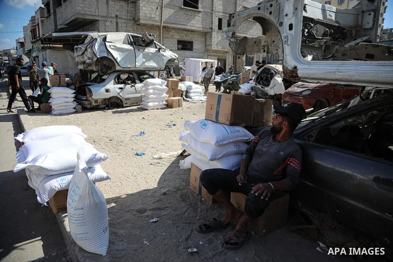 Palestinians receive food parcels distributed by the World Food Programme (WFP) at the Nuseirat refugee camp in the central Gaza Strip, on October 20, 2026. Many families continue to rely on humanitarian aid to meet thei...