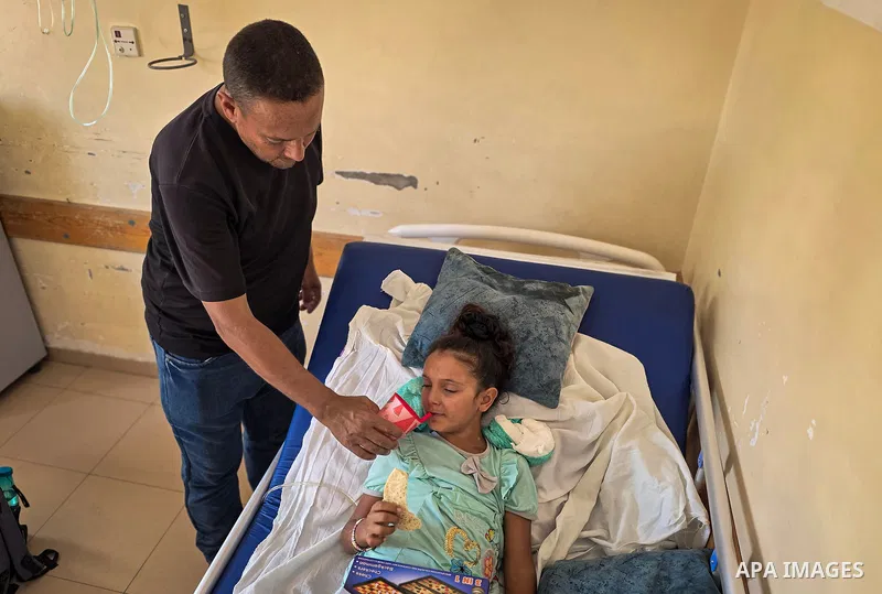 Palestinian girl Hala al-Shawaf, 11, lies on a bed at Nasser Medical Complex in Khan Younis, southern Gaza Strip, on October 22, 2026, where she is receiving treatment after being wounded in the neck by Israeli gunfire,...