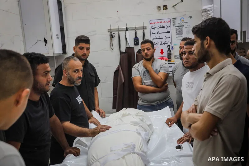 Palestinians mourn over the bodies of two people killed in an Israeli drone strike targeting an electric bicycle near the al-Sinaa junction in southwestern Gaza City, at al-Shifa Hospital in Gaza City, on October 22, 202...
