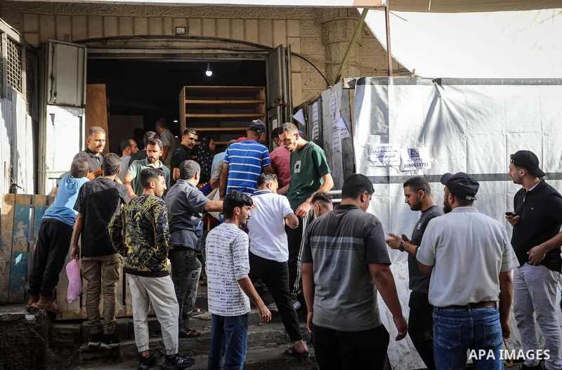Palestinians gather to receive bread from a bakery in the al-Daraj neighborhood of Gaza City, on October 22, 2026, amid worsening shortages of flour and food supplies. The Gaza Strip's Bakers Association said on Thursday...