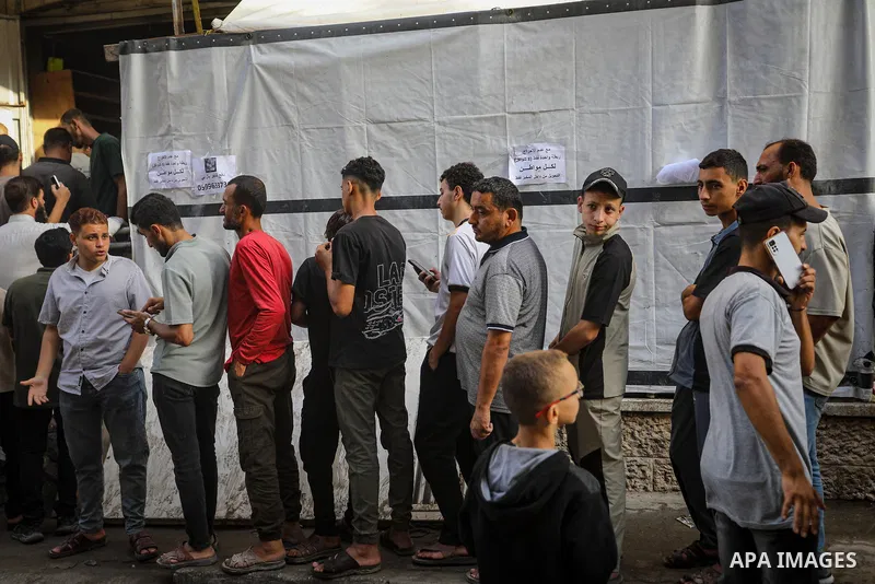 Palestinians gather to receive bread from a bakery in the al-Daraj neighborhood of Gaza City, on October 22, 2026, amid worsening shortages of flour and food supplies. The Gaza Strip's Bakers Association said on Thursday...