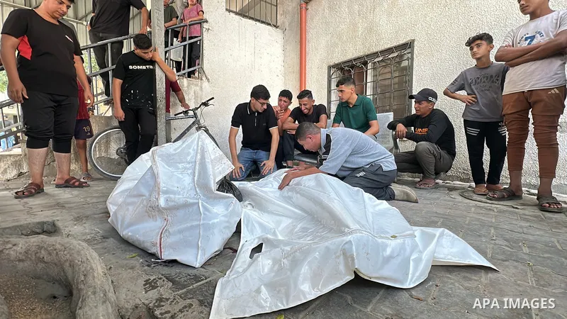 Mourners gather around the bodies of two Palestinian men at al-Shifa Hospital in Gaza City, on October 23, 2026. The two men were killed in an Israeli drone airstrike targeting the Al-Nasr neighborhood of Gaza City. Phot...