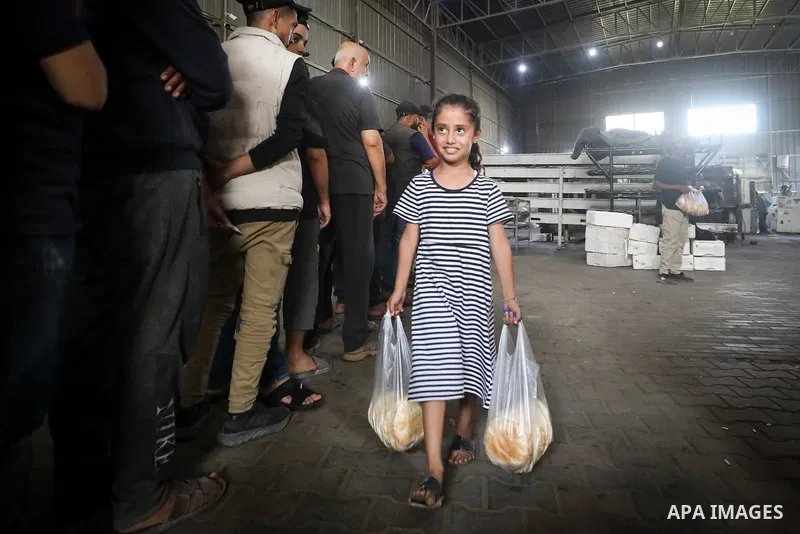 Palestinians and officials from the Egyptian relief committee for the people of the Gaza Strip oversee the delivery of an Egyptian aid convoy loaded with bags of flour in al-Zawaida, central Gaza Strip, on October 24, 20...