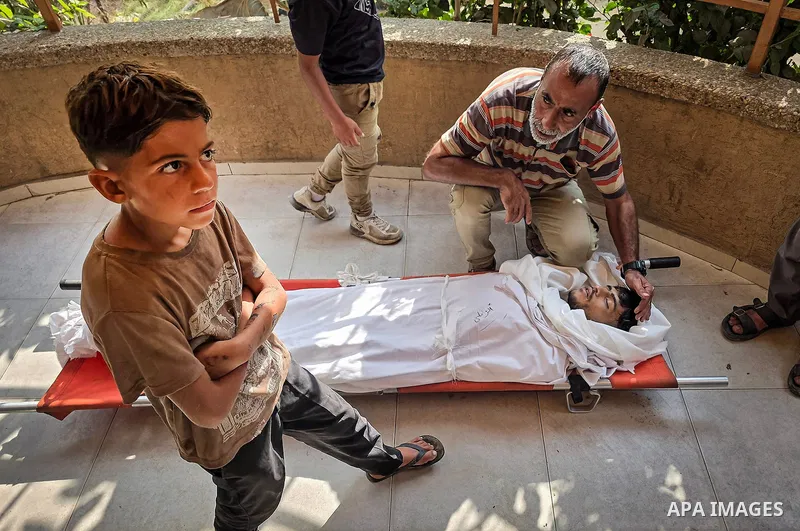 Mourners attend the funeral of Palestinians Hussam al-Zamli, child Jouri al-Soufi and Tamer Abu Sneima in Khan Younis, southern Gaza Strip, on October 26, 2026. The three were killed by Israeli forces' gunfire in the al-...