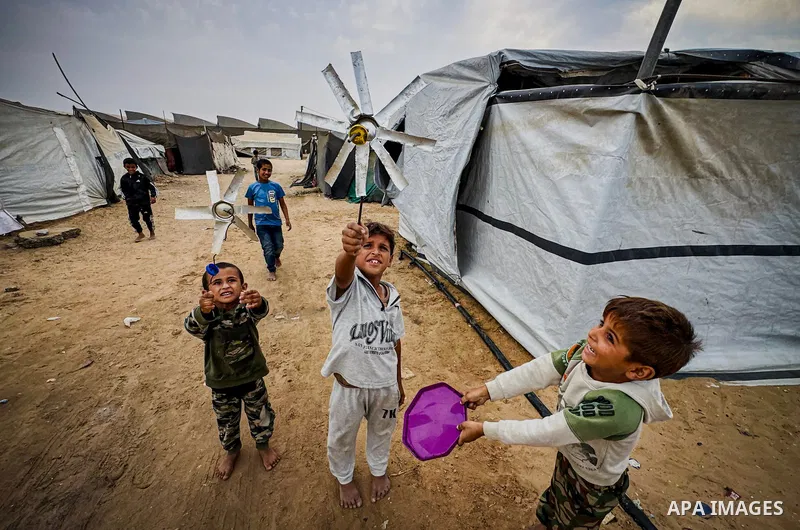 Displaced Palestinians recycle metal and plastic pieces recovered from the rubble of destroyed homes to build improvised wind turbines above their tents in the al-Mawasi area of Khan Younis, southern Gaza Strip, on Octob...