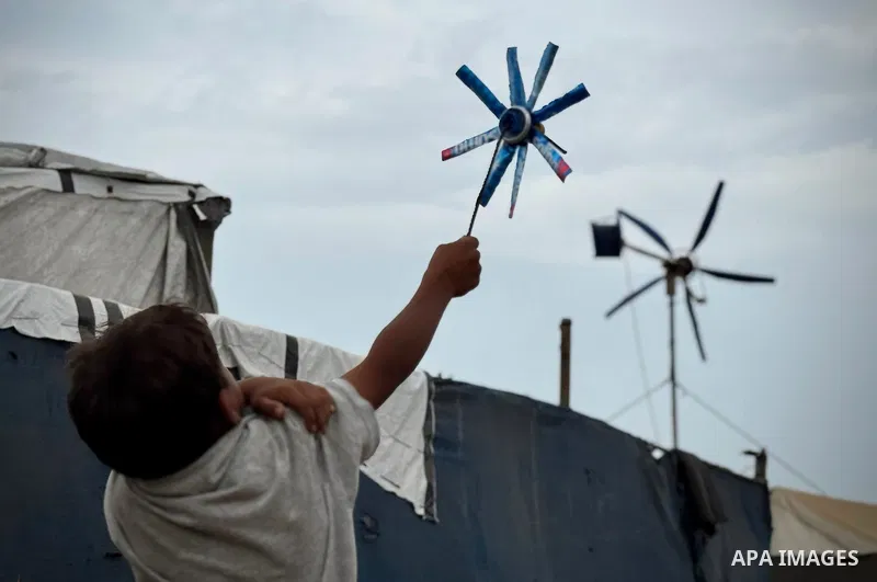 Displaced Palestinians recycle metal and plastic pieces recovered from the rubble of destroyed homes to build improvised wind turbines above their tents in the al-Mawasi area of Khan Younis, southern Gaza Strip, on Octob...
