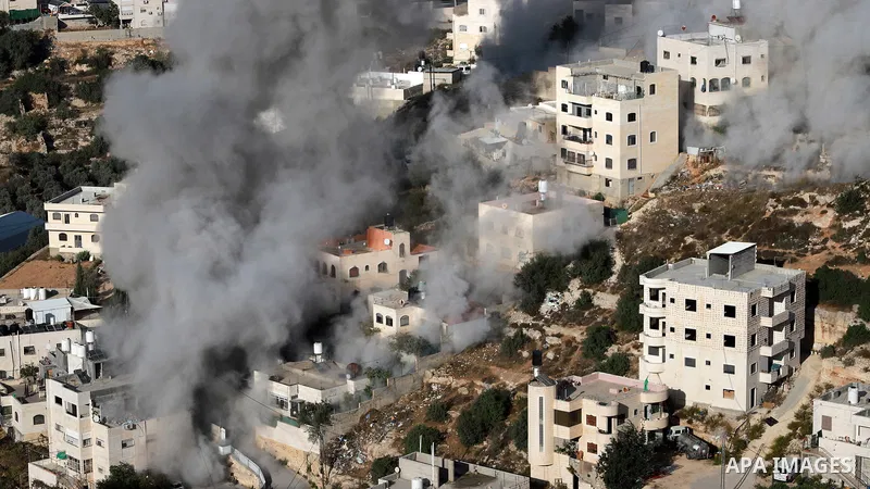 Smoke rises as Israeli troops demolish two Palestinian homes with explosives in the Ein Deir Baha area of Hebron, in the occupied West Bank, on October 30, 2026. The homes belonged to Hammouda Wael Mohammed al-Jubeh and...