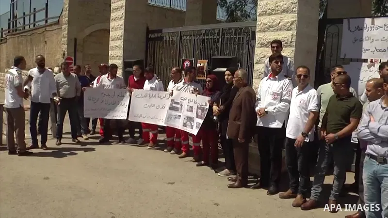 Palestinian ambulance officers take part in a protest demanding their rights in front of the headquarters of the Red Crescent Society in the West Bank city of Al-Bireh. 0.1